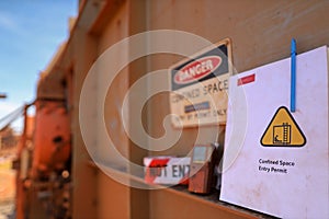 Defocused danger confined space permit entry by permit only warning sign