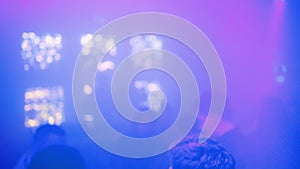 Defocused: DJ playing while people partying and clubbing at a nightclub