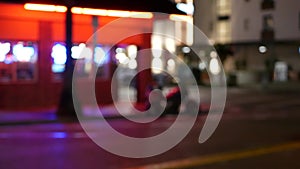 Defocused evening street. Lights of city, cars on rainy night. Road in soft focus. Twilight in USA.