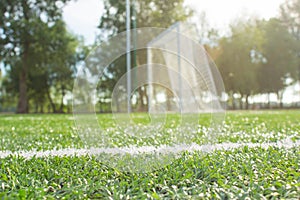 Defocused football goal on green grass early in the morning.