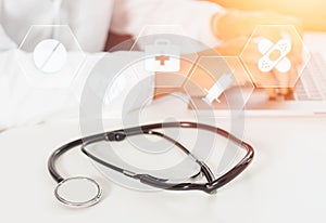 Defocused image of a doctor working with laptop computer in medical workspace office as concept with stethoscope