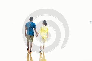 Defocused image of an Indian couple holding hands walking romantic on beach on vacation travel holidays leaving footprints in the