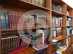 Defocused image. Multi-colored books on the bookshelf in the library. The bokeh effect