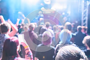 Defocused image of people crowd at concert and stage lights