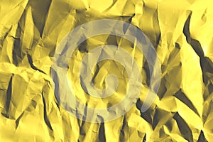 Defocused image of yellow crumpled paper texture. Abstract backdrop.