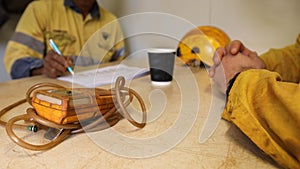 Construction worker Asian hand written Job Hazard Analysis JHA risk assessment on the table photo