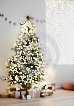 Defocused magic christmas interior with christmas tree, stars, gifts and decoration