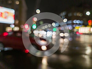 defocused night rain city street cross roads view with red car