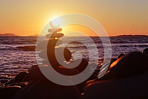 Defocused pebble pyramid and transparent sea background. Orange