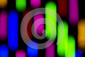 Defocused of photo bokeh blurred circle light from colorful neon lighting bulb in the night for abstract background