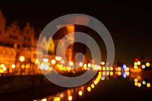 Defocused photo of Old town in Gdansk at night for greeting card background. The riverside on Granary Island reflection
