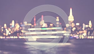 Defocused picture of New York City waterfront skyline at night, color toned urban abstract background, USA