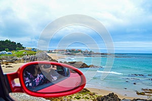 Defocused rearview mirror of a red car with Comillas Cantabria,