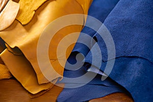 Defocused rolls of natural brown and blue leather. Concept of materials for leather craft