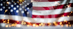 Defocused US flag with bokeh lights and sparklers. Fourth of July Independence Day background