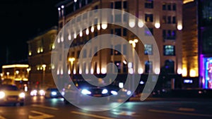 Defocused view of a busy city street. Night. Heavy traffic. Colorful buildings