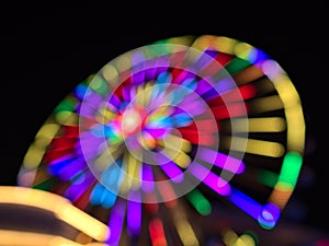 Defocused view in the dark of colorful Ferris wheel in park Wurstelprater near Wiener Prater in city Vienna, Austria.