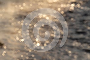 The defocused view of fresh river stream water slowly flowing through natural rock beach in the morning. Abstract nature