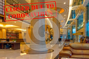 Defocused view of interior of an upmarket hotel reception, empty and closed due to coronavirus