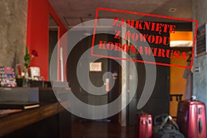 Defocused view of interior of an upmarket hotel room, empty and closed with Polish notice Closed due to Coronavirus