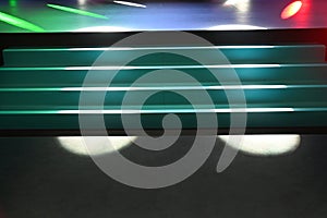 Defocused view of staircase to empty stage with multicolor spotligt rays