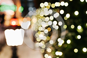 Defocusing Christmas lights, decorated with glowing Christmas tree at night outdoors.