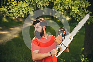 Deforestation. Man doing mans job. Lumberjack worker with chainsaw in the forest.