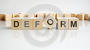 DEFORM text on a wooden blocks, gray background