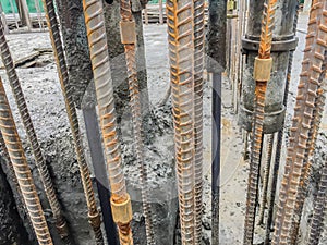 Deformed steel bar was connected in the reinforce cement column by the jacket connector in the construction site. Rusty deformed
