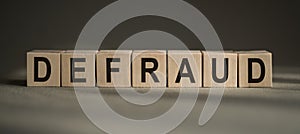 Defraud Word Written In Cubes on a black and grey background photo
