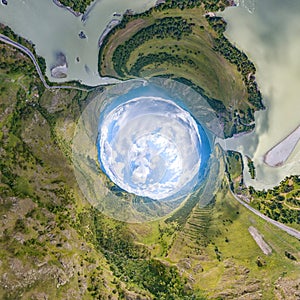 360 degree panoramic of an abstract world turned inside out with green meadows around an oval sky with clouds