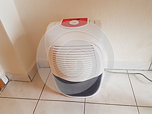 dehumidifier on the floor white red plastic