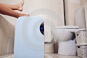 Dehumidifier with touch panel, humidity indicator, uv lamp, air ionizer, water container works in bathroom. Air dryer