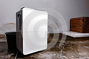 The dehumidifier works in a room with a mold and water on the floor.