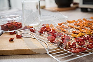 Dehydrate dried yellow and red tomatoes on stainless steel dehydrator tray and in glass jar for long term pantry in domestic