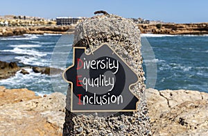 DEI diversity equality inclusion symbol. Concept words DEI diversity equality inclusion on yellow blackboard. Beautiful stone