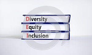 DEI, Diversity, equity, inclusion symbol. Books with words DEI, diversity, equity, inclusion on beautiful white background.