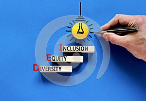 DEI diversity equity and inclusion symbol. Concept words DEI diversity equity inclusion on blocks. Beautiful blue background.