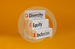 Diversity, equity, inclusion symbol. Wooden blocks with words DEI, diversity, equity, inclusion on beautiful orange photo