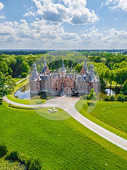 DEINZE, BELGIUM, BELGIUM - Jun 21, 2019: Aerial view of the Ooidonk castle surrounded by water and trees