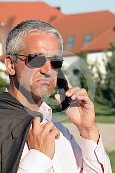 Dejected businessman using cell phone