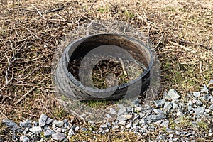 Delaminated truck tire in a ditch by a road..