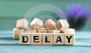 DELAY - word on wooden cubes on a green background with lavender