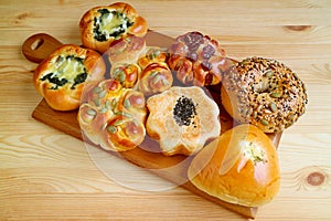 Delectable assorted sweet and savory breads on a wooden tray served on wooden table