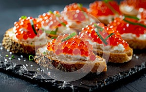 Delectable caviar-topped canapes made with crusty bread, a creamy spread, and glistening orange fish roe, garnished with