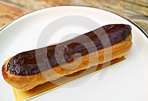 Delectable Chocolate Eclair on a White Plate