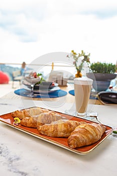 Delectable Croissants with Coffee on a Scenic Terrace