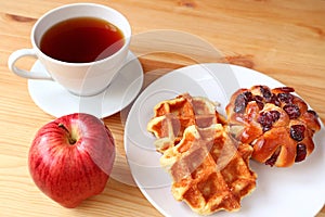 Delectable Pastries with a Cup of Hot Tea and Fresh Apple