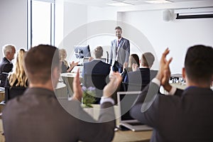 Delegates Applauding Businessman Making Presentation