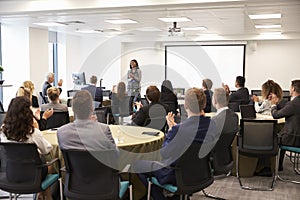 Delegates Applauding Businesswoman Making Presentation